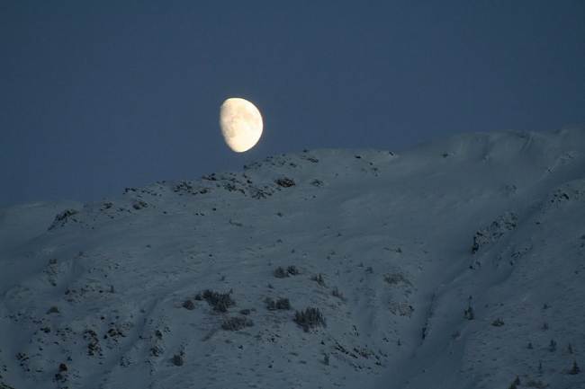 The moon over snow-clad peaks in the Yukon