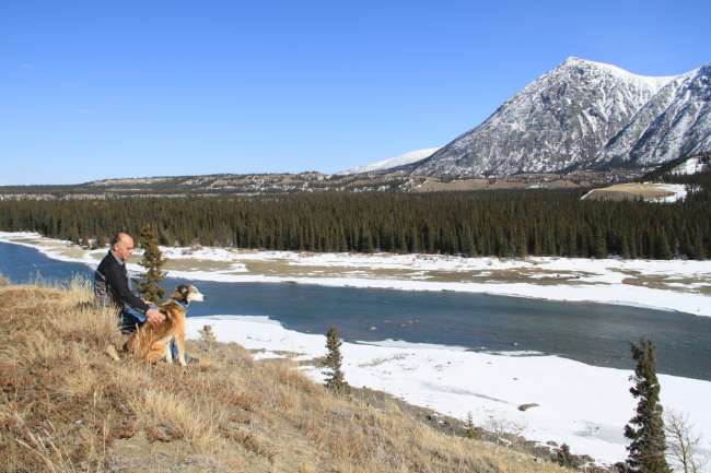 Murray Lundberg and his husky Monty above the Tahini River in the Yukon