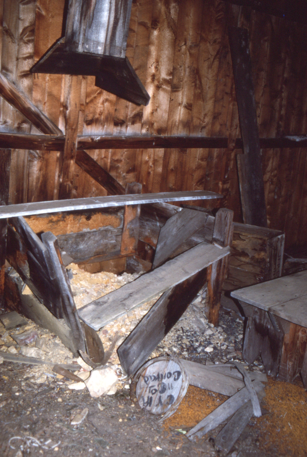 Inside the blacksmith shop. A keg of nails broken open is addressed to CYM (Conrad Yukon Mines), Conrad.