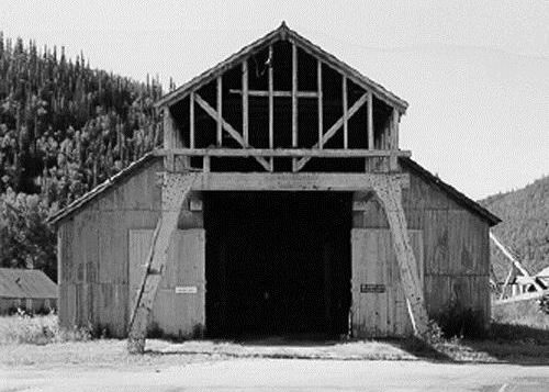 Facade of the Machine Shop, showing the distinctive overhead crane housing projecting from its front gable, 1988. Photo by Parks Canada.