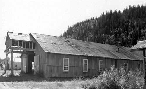 General view of the Machine Shop, showing its simple rectangular shape, its gable roof and its corrugated metal siding and roof covering, 1988.