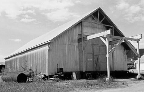 Corner view of Warehouse No. 3 at Bear Creek, showing the front double doors and the overhanging roof, 1988. Photo by Parks Canada.