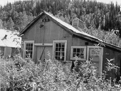 View of the main entrance to the Tin Shop, showing the arrangement and detailing of the double doors and the windows of the front gable, 1988. Photo by Parks Canada.