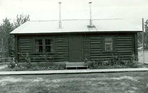 Front elevation of the N.W.M.P Married Officers' Quarters at Dawson, showing the log construction of peeled local spruce logs, sawn on three sides and lapped at the corners, 1987. Photo by Parks Canada.