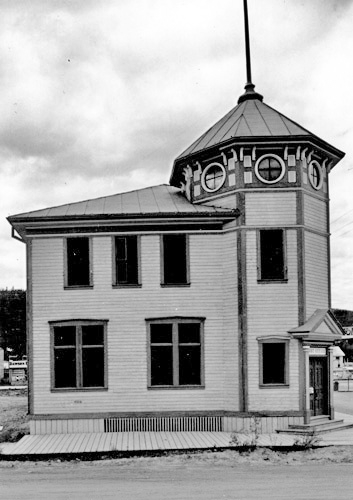 View of the front entrance of the Post Office in Dawson, showing the octagonal tower, which gives the building a sense of stability, defines the entry and provides an important focal point in the town, 1987. Photo by Parks Canada.