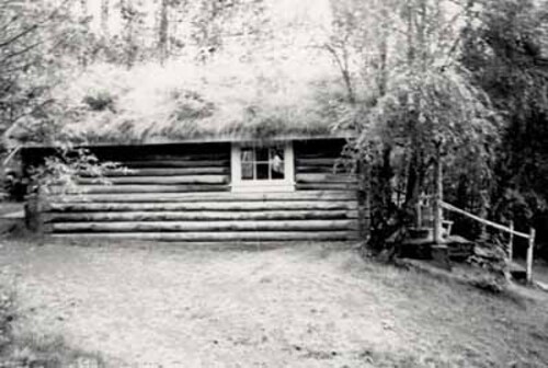 Side view of the Robert Service Cabin, showing the rustic, low-lying form, 1987. Photo by Parks Canada.