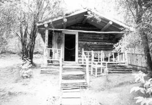 Facade of the Robert Service Cabin, showing the one-storey massing which consists of a two-room structure with a gable roof, 1987. Photo by Parks Canada.