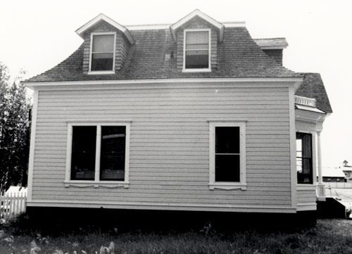 Side view of St. Andrew's Manse, showing the mansard-roofed main structure and the <br>projecting dormers, 1987. Photo by Parks Canada.