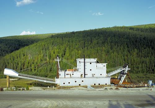 General view of Dredge No. 4 showing its setting in the field of dredging activity near Bonanza Creek, 1996. Photo by J Butterill, via Parks Canada.