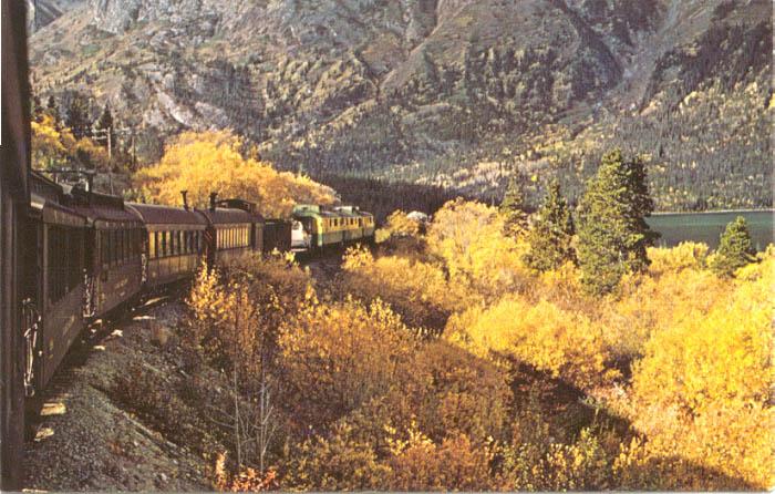 A historic postcard showing a WP&YR passenger train along Lake Bennett south of Carcross in the 1960s.