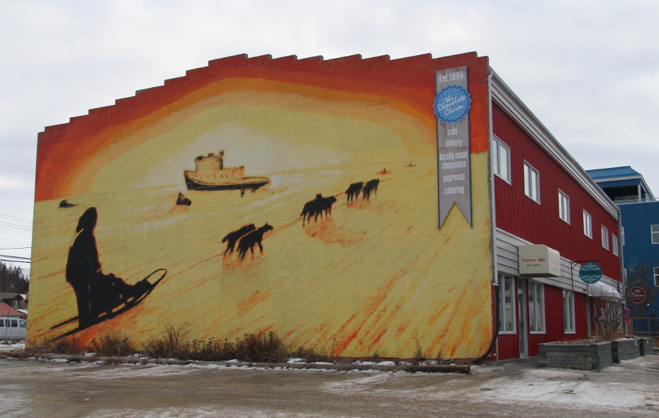 Mural of dog sledding at sunset by Colin Alexander in Whitehorse, Yukon
