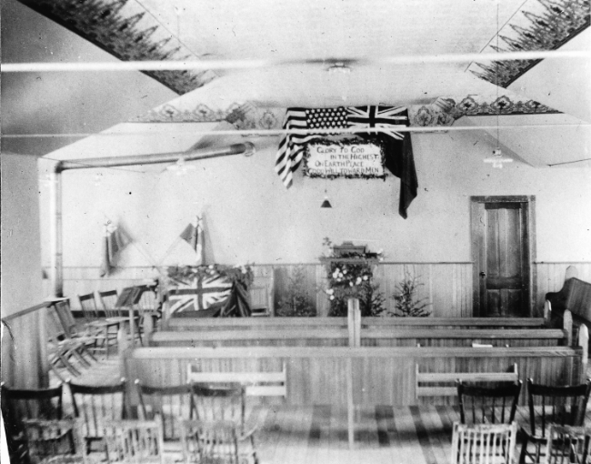 Pews and pulpit decorated for Christmas, Whitehorse, Yukon Territory, 1900