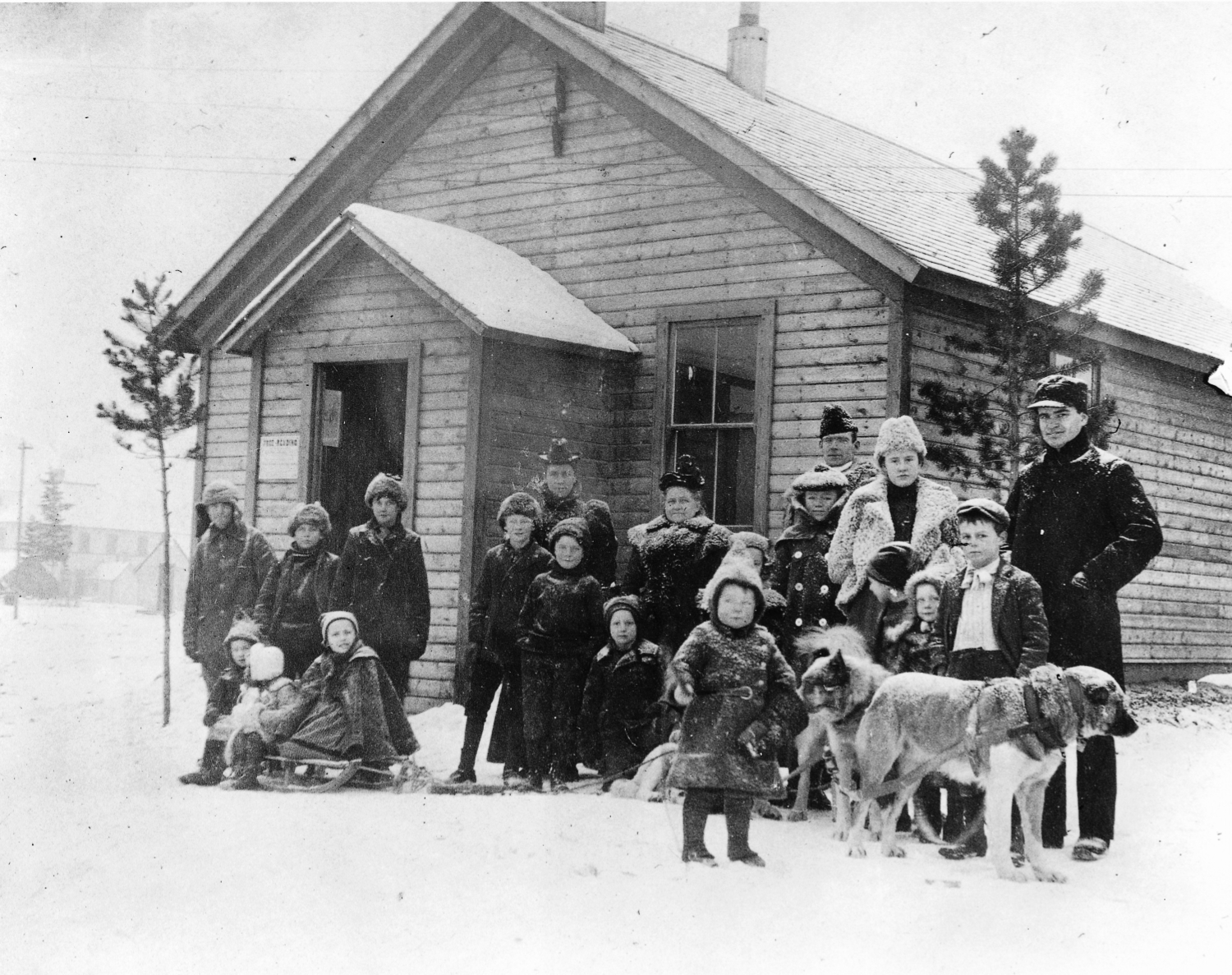 A group of children and adults with a dog sled - Whitehorse, Yukon Territory, 1900